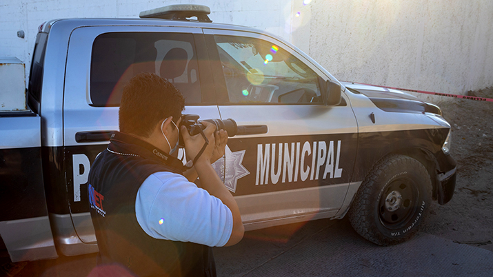 Photographer by police vehicle